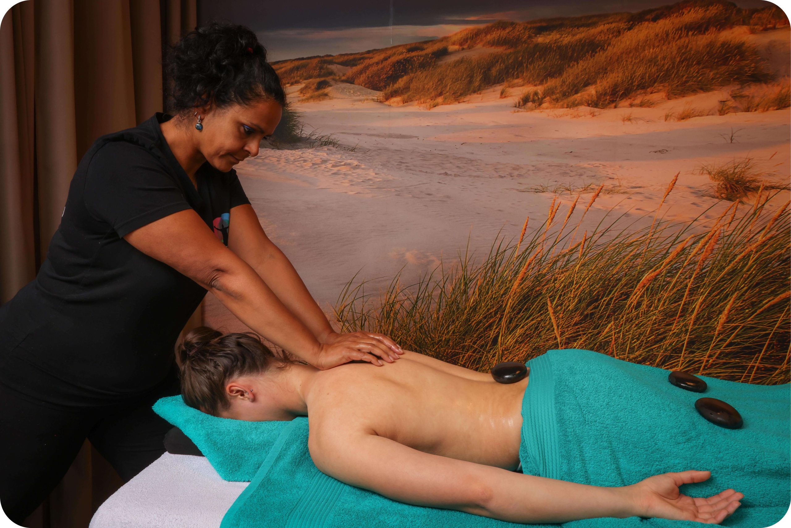Noewara Wink geeft een dame een hotstone massage