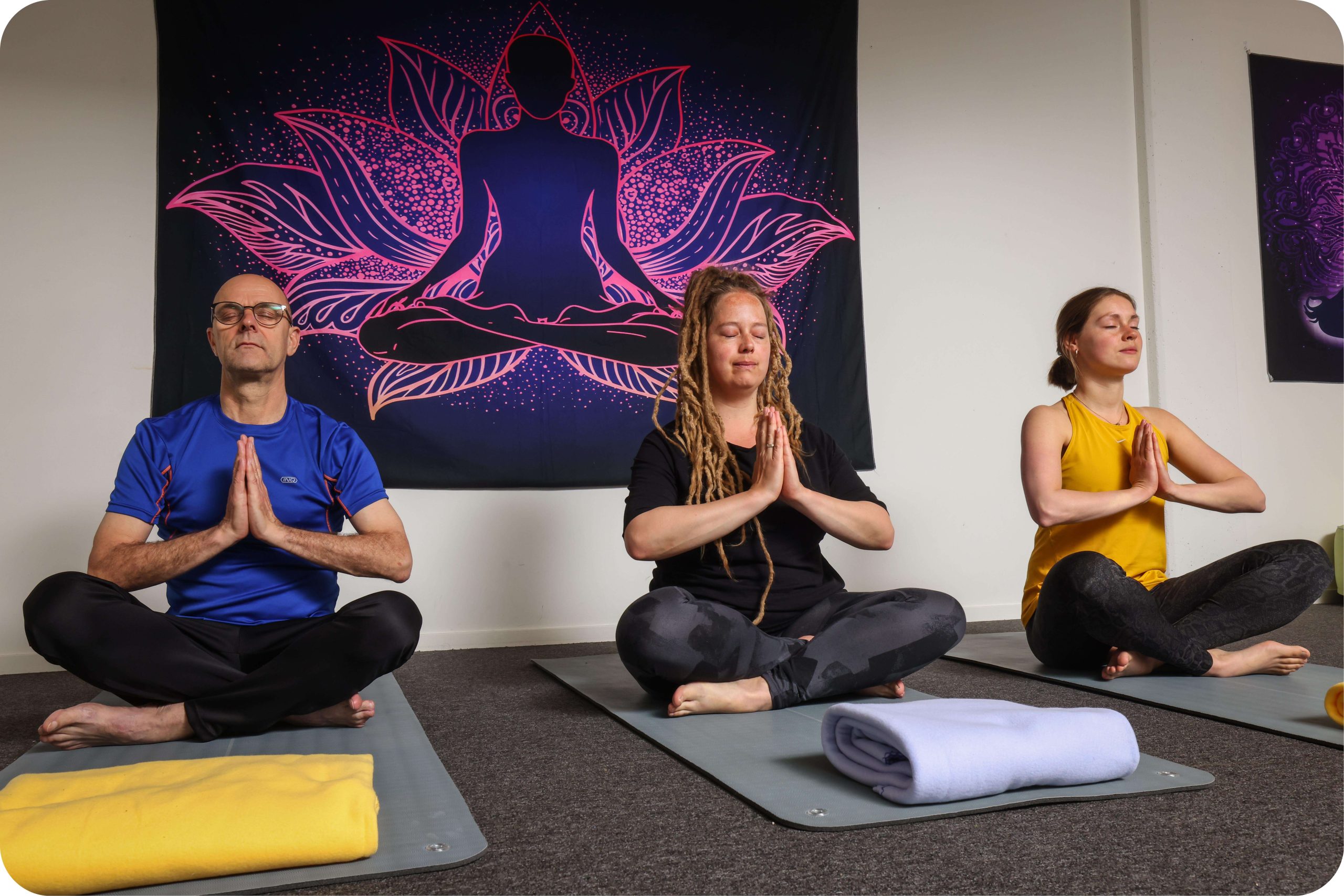 Drie mensen die yoga uitvoeren